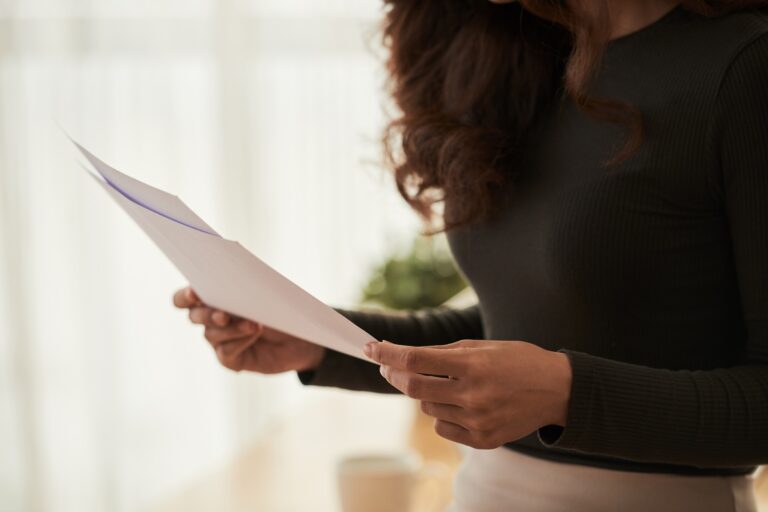 Imagem recortada de mulher de negócios lendo documentos nas mãos