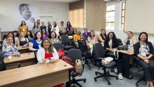 participantes do seminário, maioria mulheres, posam sorridentes para a foto