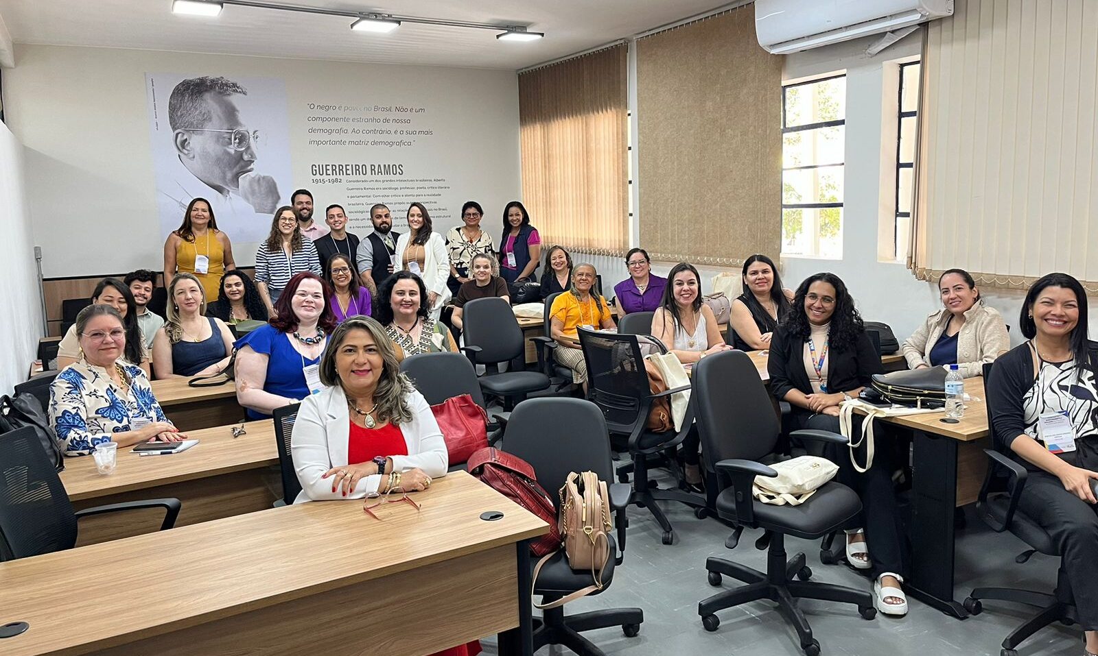 participantes do seminário, maioria mulheres, posam sorridentes para a foto