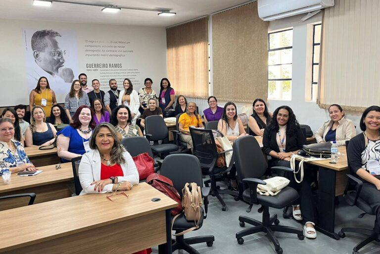 participantes do seminário, maioria mulheres, posam sorridentes para a foto